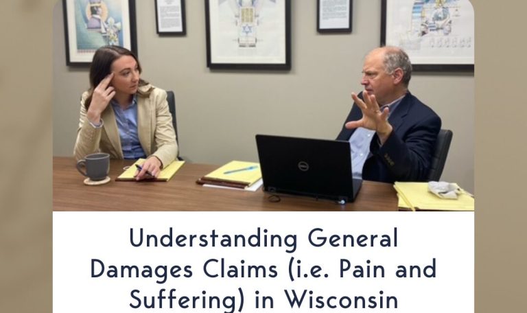 Two legal professionals engaged in discussion at a conference table, symbolizing the importance of understanding general damages in Wisconsin personal injury cases.